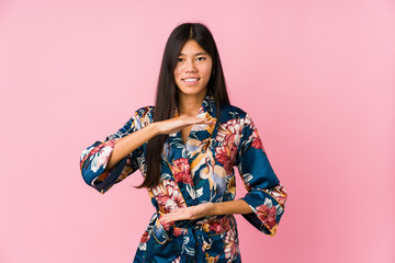 Young asian woman wearing a kimono pajamas holding something with both hands, product presentation.