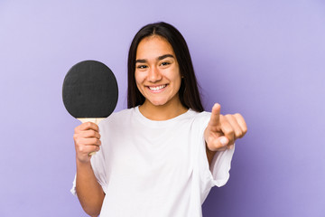Young indian woman playing ping pong isolated cheerful smiles pointing to front.