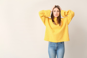 Stressed young woman on light background. Concept of choice