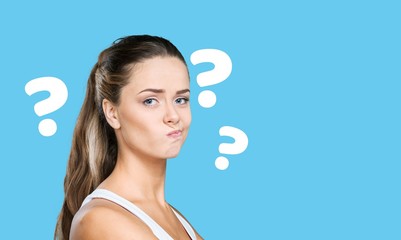 Question sign with a beautiful alarmed woman on pastel background