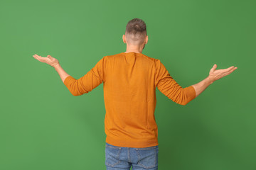 Helpless man on color background, back view. Concept of choice