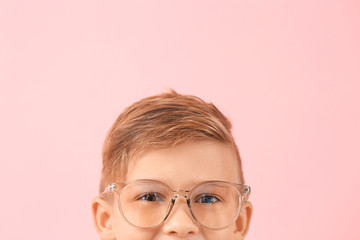 Obraz premium Cute little boy with eyeglasses on color background