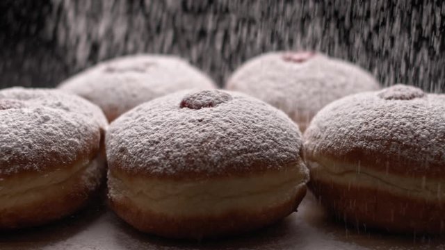 Spreading sugar powder on hanukkah jelly doughnuts, slow motion, BMPCC 4K
