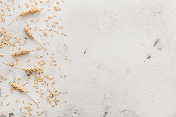 Scattered raw oatmeal on light background