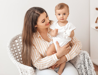 Happy mother with cute little baby at home