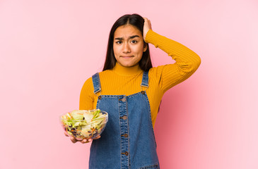 Young asian woman holding a salad isolated being shocked, she has remembered important meeting.