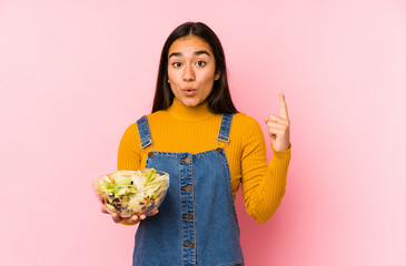 Young asian woman holding a salad isolated having some great idea, concept of creativity.