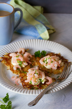 Potato cakes with topping: cream cheese and shrimps on white plate. Vegetable fritters, pancakes. Vertical image