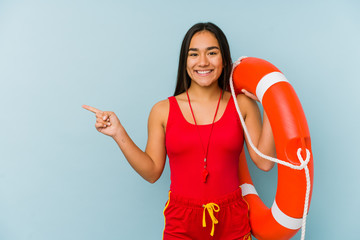 Young asian lifeguard woman isolated smiling and pointing aside, showing something at blank space.