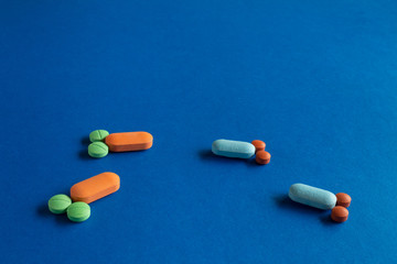 Pills and tablets forming small penises and testicles. Concept of masculinity, male dominance and gay encounters. Medications for erectile dysfunction