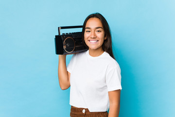 Young indian woman holding a vintage cassete isolated