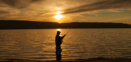 silhouette of man on sunset fishing