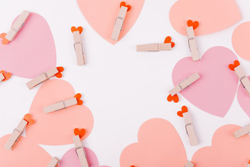 Beautiful greeting card design with a cosy bunch of overlapping warm and tender pink hearts anchored together with clothes pegs. Copy Space for Texts