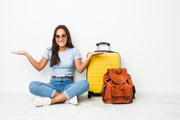 Young mixed race indian woman ready to go to travel makes scale with arms, feels happy and confident.