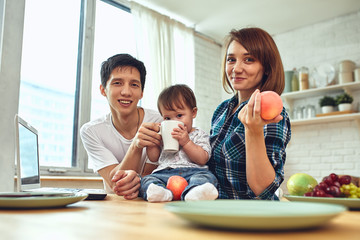 Happy international family concept. Dad, mom, son and little daughter posing for a camera at home, are engaged in home parenting. Home holidays, parenting, concept children and parents.