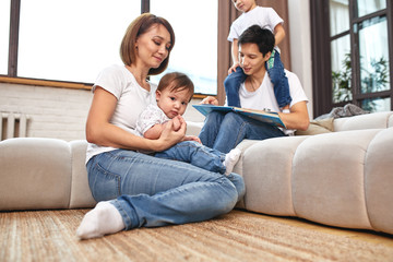 Happy international family concept. Dad, mom, son and little daughter posing for a camera at home, are engaged in home parenting. Home holidays, parenting, concept children and parents.