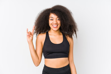 Young african american sporty woman showing a horns gesture as a revolution concept.