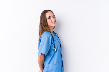 Young nurse woman isolated looks aside smiling, cheerful and pleasant.