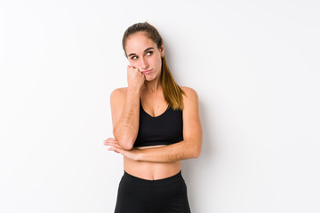 Young caucasian fitness woman posing in a white background who feels sad and pensive, looking at copy space.