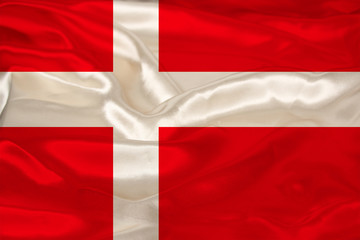 photo of the national flag of Denmark on a luxurious texture of satin, silk with waves, folds and highlights, close-up, copy space, concept of travel, economy and state policy