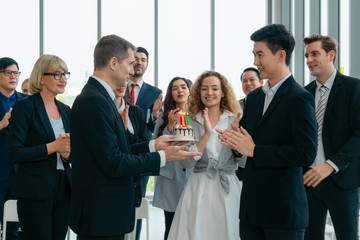 business background of birthday celebration of young male business executive in office with many colleagues happy together