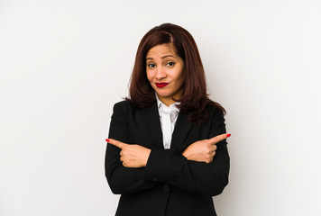 Obraz premium Middle age latin business woman isolated points sideways, is trying to choose between two options.
