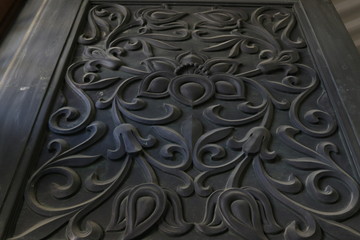 Textura de relieve grabado en puerta de madera negra en un templo de Asia