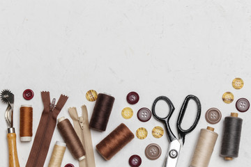 Set of different sewing items on white textured background	