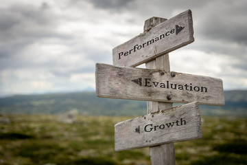 performance, evaluation and growth text on wooden road sign outdoors in nature.