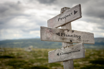 project, planning and competence text on wooden road sign outdoors in nature.