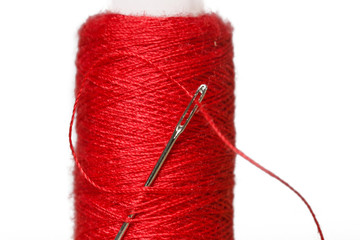 Spool of red thread and needle macro photography