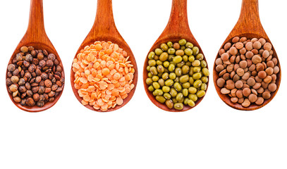 Collection of various lentils in a wooden spoons isolated on a white background. Top view.