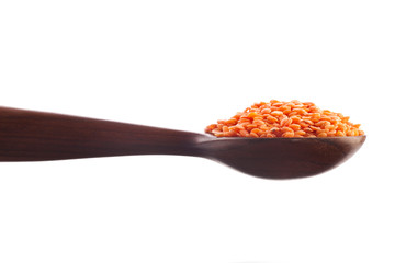 Fototapeta na wymiar Red lentils in the wooden spoon isolated on a white background.