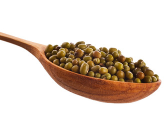 Green lentils in the wooden spoon isolated on a white background. Top view.
