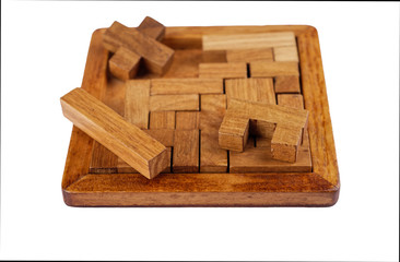 Selective focus. Three-dimensional wooden pentamino board game on a white background.