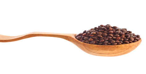 Brown lentils in the wooden spoon isolated on a white background.