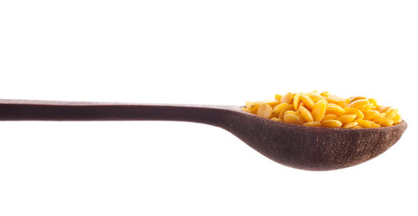 Yellow lentils in the wooden spoon isolated on a white background.
