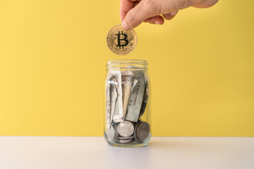 Hand drop gold Bitcoin the jar full of coin and bank notes meaning of saving investment with...
