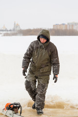 Portrait of a builder on the ice of a frozen river in January day