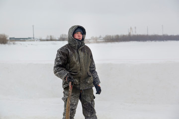 Fototapeta na wymiar Portrait of a builder on the ice of a frozen river in January day