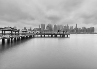 View on Financial District and J.Owen Grundy park from Hudson River on a cloudy day in black and white photo