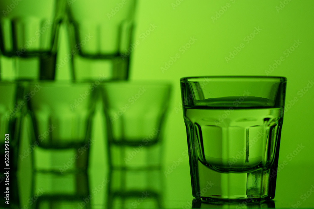 Wall mural a glass of alcohol on a green background