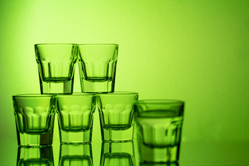 a glass of alcohol on a green background
