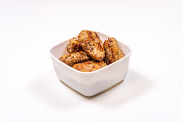 Homemade meat cutlets in a food container on a white table