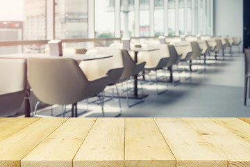 Empty table, chair in food court or foodcourt interior blurred background. Restaurant or canteen at indoor plaza, mall, store or shopping center. Include wooden counter or desk for product display.