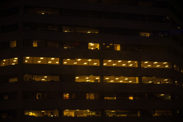 Night skyscraper closeup, glowing window. Night work