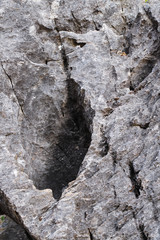 Closeup rough surface of rock with a hole. Vertical view.
