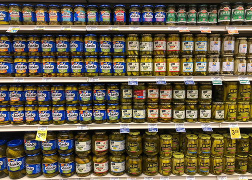 Alameda, CA - October 18, 2018: Grocery store shelf with jars of pickles in various flavors and brands.