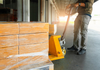 Workers Courier Using Hand Pallet Jack Unloading Package Boxes into Cargo Container. Delivery...