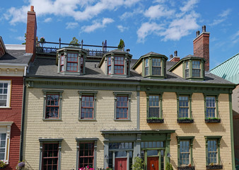 facades of colorful old clapboard houses with dormer windows